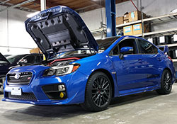 The 2015 and 2016 Subaru WRX STi, shown here in WR Blue Pearl paint, is powered by the EJ257 intercooled and turbocharged engine and equipped with an AEM performance cold air intake